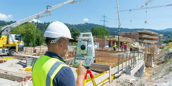 Surveyor operating a total station on a construction site